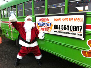 Santa waving beside the Cool Christmas Bus